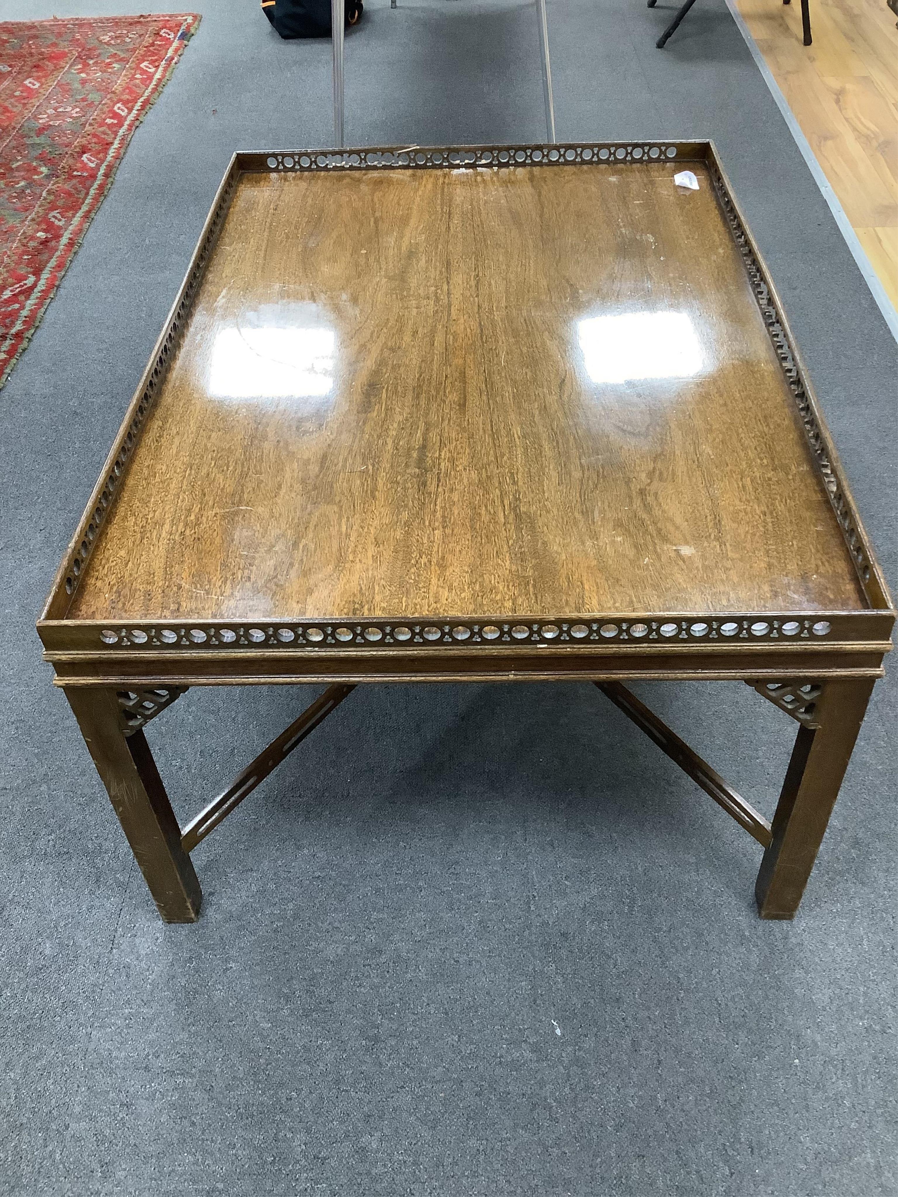 A reproduction George III style rectangular mahogany coffee table, width 106cm, depth 76cm, height 52cm. Condition - poor, fret gallery damaged in several places